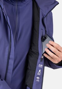 Fioletowa wodoodporna kurtka z kieszenią na zamek na telefon. Cechy obejmują materiał wiatroszczelny oraz podane specyfikacje wodoodporności.