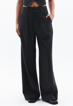 Brede pantalon van donkergrijze stof met dunne verticale strepen. Heeft een hoge taille en zijzakken. Gelaagd, op maat gemaakt ontwerp.