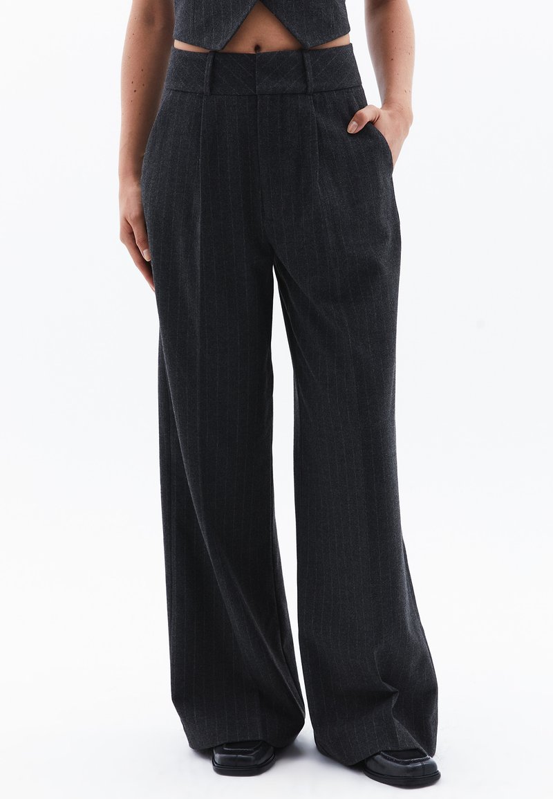 Pantaloni a gamba larga in tessuto grigio scuro con sottili righe verticali. Caratterizzati da vita alta e tasche laterali. Design strutturato e sartoriale.