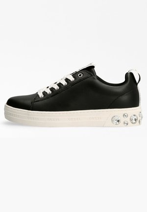 Sneaker in pelle nera con lacci e occhielli bianchi, caratterizzato da una suola testurizzata con dettagli in cristallo sul tallone e dettagli di marca sul lato.