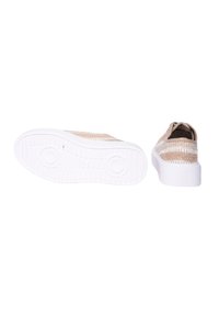Sneaker in tessuto intrecciato beige con suola in gomma bianca, caratterizzato da una silhouette piatta, punta rotonda e motivi testurizzati sulla parte superiore.