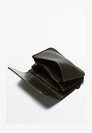 Portafoglio in pelle nera con finitura testurizzata, dotato di più scomparti, design pieghevole e bordi morbidi. Cuciture visibili come dettaglio.