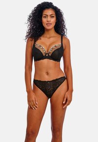 Black lace bra with floral embroidery on sheer cups and matching lace thong. Features adjustable straps and scalloped edges.