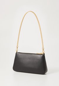 Black leather clutch bag with a triangular shape, features a gold chain strap, top zipper closure, and smooth texture.