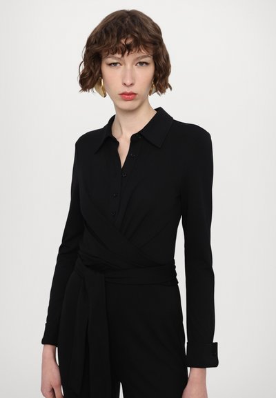 Robe noire enroulée avec manches longues, un col, des détails en boutons et une taille nouée pour une silhouette ajustée. Texture de tissu lisse.