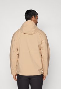Beige wasserdichte Jacke mit Kapuze, mit einer glatten Textur, langen Ärmeln und dezenten reflektierenden Akzenten am Saum.