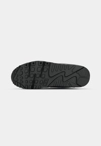 Black sneaker sole with textured rubber, featuring geometric patterns and a prominent Nike logo. Flat design for traction and stability.
