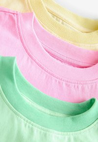 Drei Crewneck-T-Shirt-Kragen übereinander gestapelt. Die Farben sind hellgrün, pink und gelb. Der Stoff wirkt weich mit gerippten Halsbündchen.