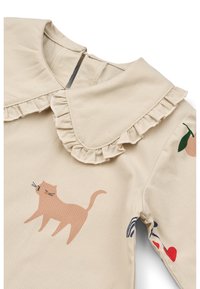 Camicia beige a maniche lunghe con colletto arricciato, caratterizzata da una grafica di un gatto rosa e stampe colorate di frutta e strisce sulle maniche. Materiale in cotone.
