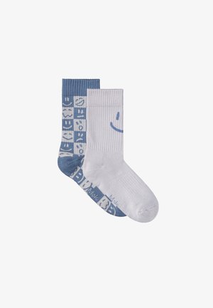 Skarpetki z mieszanki bawełny, jedna niebieska z uśmiechami, druga biała z dużym uśmiechem. Prążkowana tekstura, średnia wysokość.