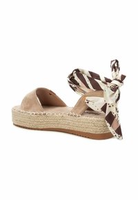 Espadrilles de ante beige con una suela de yute trenzado, que presentan un lazo en el tobillo de tejido estampado en rayas marrón y crema.