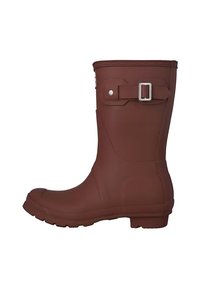 Bota de lluvia de goma marrón con suela plana, punta redonda, ligero tacón, correa ajustable con hebilla y superficie texturizada para agarre.