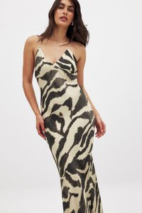 Robe maxi en tissu léger avec un imprimé animal noir et crème, présentant un décolleté en V, des bretelles fines et une silhouette ajustée.