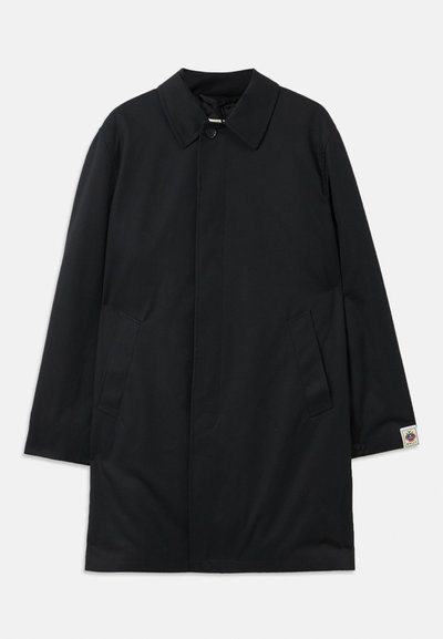 Black coat with a structured collar and button closure, featuring two side pockets and a logo patch on the left sleeve. Smooth fabric texture.