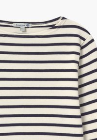 Stribet langærmet skjorte i creme med marineblå vandrette striber. Rundet halsudskæring og blødt bomuldsstof. Mærket siger "Armor-kids, 6A."