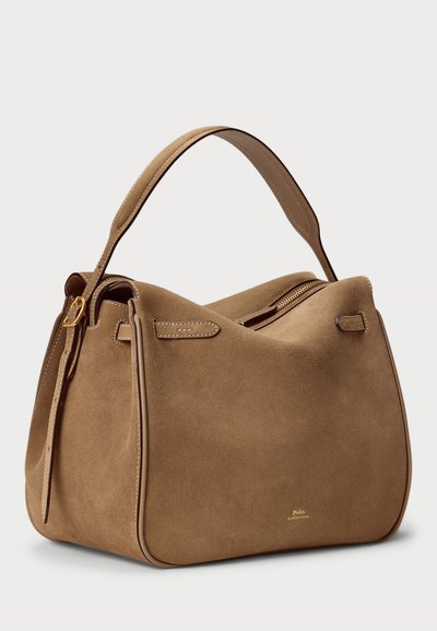 Sac en daim de couleur marron clair avec une texture lisse, un contraste de bordures foncées, une fermeture éclair et une seule poignée courte.