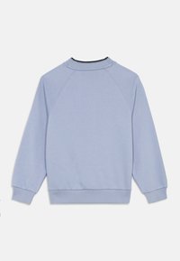 Ανοιχτό γαλάζιο φούτερ μακρύ μανίκι με ριμπ στα μανίκια και στο τελείωμα, που δείχνει το πίσω μέρος σε λευκό φόντο.