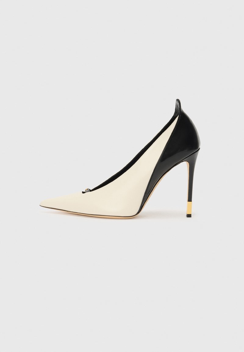 Chaussure à talon haut à bout pointu en cuir verni noir et en cuir crème. Présente un talon accentué de doré et un design épuré.