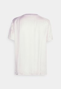 T-shirt branca de manga curta com uma textura suave, decote redondo e barra ligeiramente arredondada. Gradiente subtil do branco para o rosa claro.