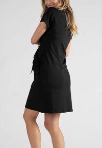 Schwarzes Kleid aus einem glatten Stoff, mit kurzen Ärmeln und einem gebundenen Detail an der Taille, in lockerer Passform und knieumspielender Länge.