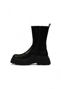 Bottines en cuir noir avec une semelle en caoutchouc épaisse, fermeture éclair sur le côté et languette à l'arrière. Texture lisse avec un design épuré.