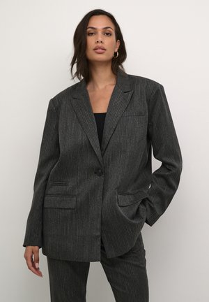 Blazer gris a rayas con cierre de un solo botón, dos bolsillos frontales y un corte entallado. La tela tiene una textura suave con un ligero brillo.