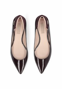Ballerine in pelle laccata bordeaux con punta affusolata e lati sagomati. Morbida fodera interna e un piccolo dettaglio argento sul tallone.