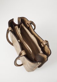 Bruine handtas met een patroon en een gestructureerde afwerking, voorzien van dubbele handvatten en een ritscompartiment. Het interieur is beige met merkdetails.