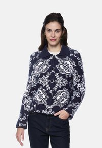 Navy sweater with a floral white pattern, featuring a collared neck and button closure. Textured knit fabric with long sleeves.