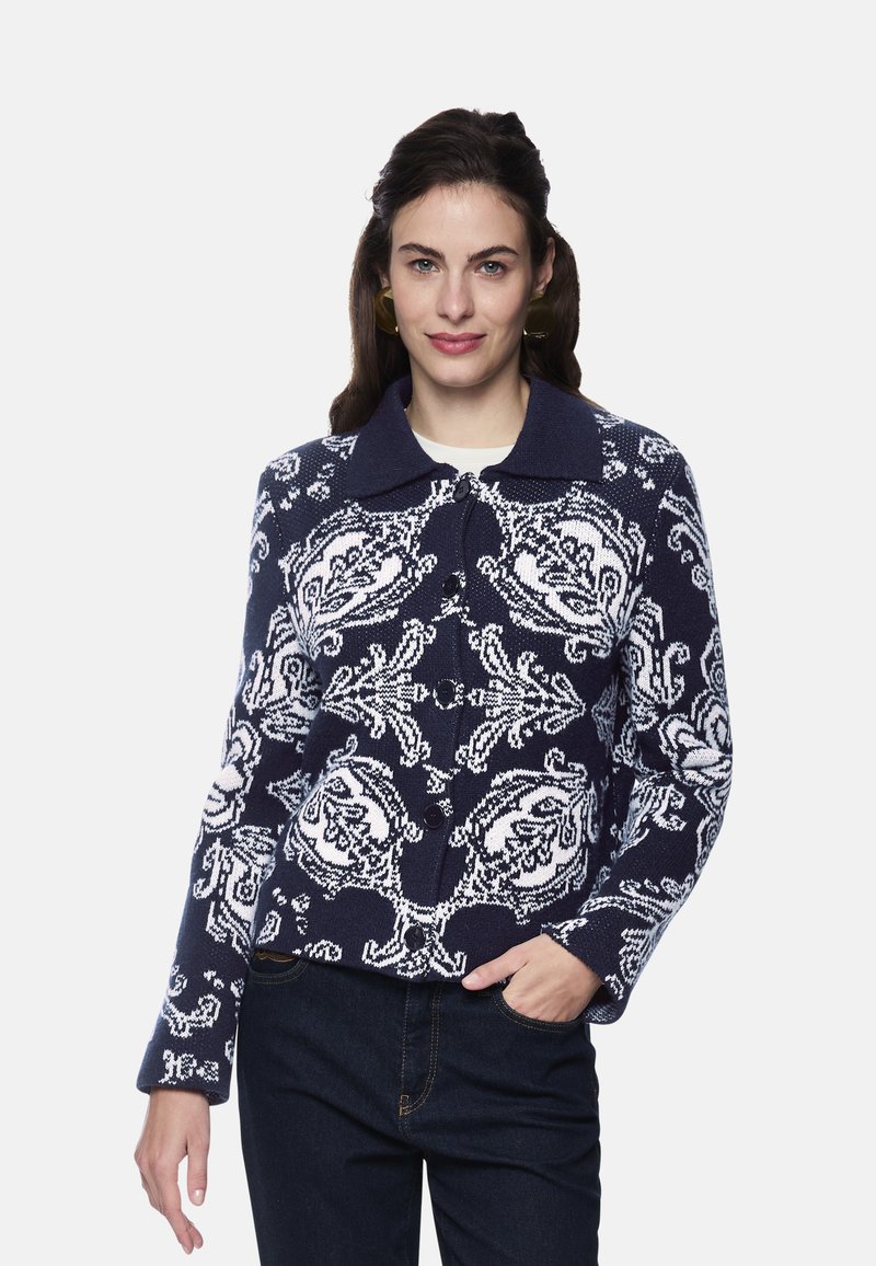 Navy sweater with a floral white pattern, featuring a collared neck and button closure. Textured knit fabric with long sleeves.