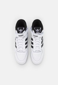 Høje sneakers i hvid og sort læder med tre sorte striber, perforeret tå og en velcro-rem for ekstra støtte.