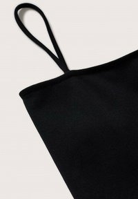 Top sans manches, noir et ajusté, en tissu lisse, avec des bretelles fines et un décolleté droit dans un design minimaliste.