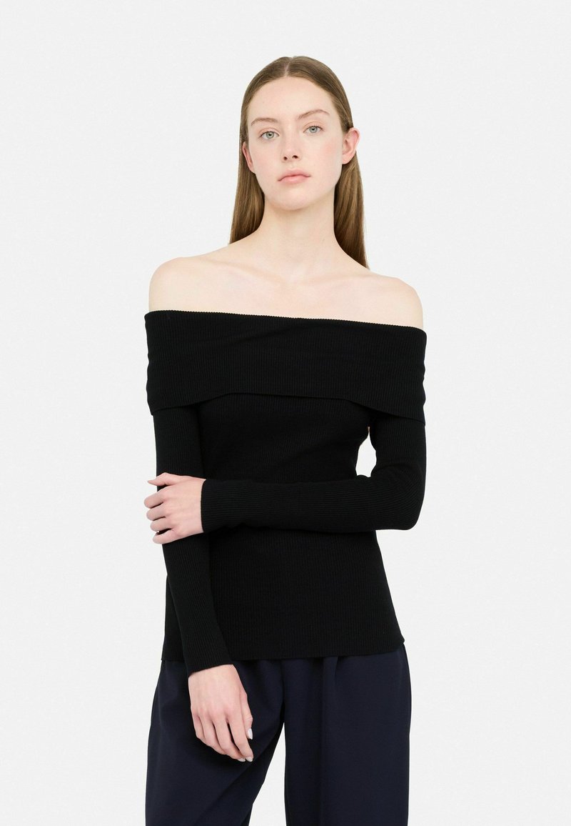 Top nero a spalle scoperte in maglia a coste con maniche lunghe, caratterizzato da un collo ripiegato e tessuto testurizzato. Il modello si trova contro uno sfondo bianco.