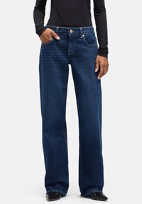 Ciemnoniebieskie dżinsy o szerokich nogawkach wykonane z denimu. Posiadają przednie kieszenie, zapięcie na guzik oraz subtelne detale przeszyć.
