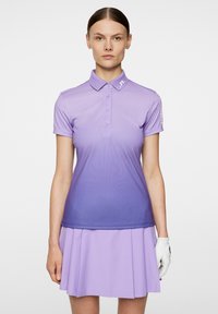 Lilla golf polo skjorte med gradientdesign, korte ærmer og krave. Har knapper og brandede detaljer på ærmet.