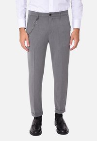 Pantaloni grigi eleganti con vestibilità slim, caratterizzati da un accento a catena attaccato all'asola della cintura, la trama del tessuto appare liscia e leggermente strutturata.