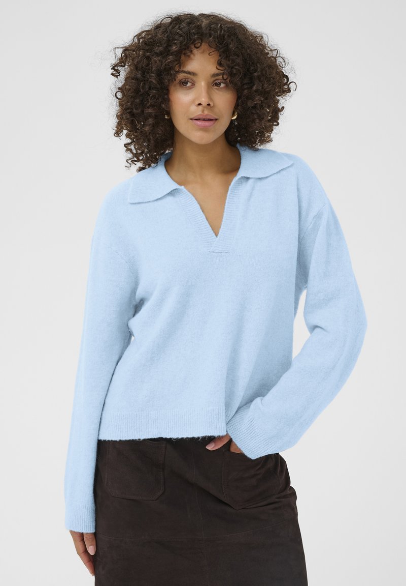 Pull bleu clair en maille avec col en V et col, manches longues et coupe décontractée, fabriqué en matière douce avec une finition texturée.