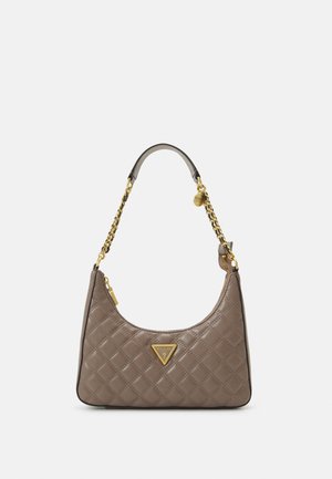 Beżowa pikowana skórzana torebka na ramię z złotym łańcuszkiem jako paskiem i trójkątną plakietką z logo Guess na środku z przodu.