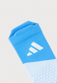 Chaussette de sport bleu clair avec texture côtelée, arborant un logo Adidas blanc et un motif en nid d'abeille sur la semelle pour une meilleure adhérence.
