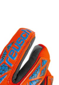Orange goalkeeper gloves with black mesh fabric and blue accents. Features include a reinforced wrist strap and textured grip surface.