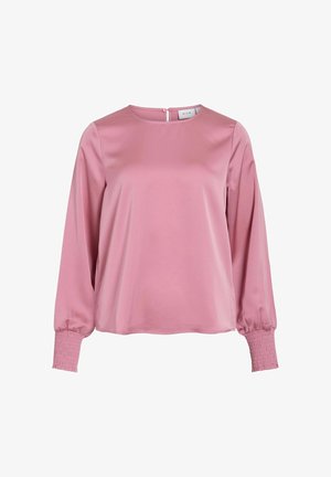 Pikkade varrukatega roosa satiinblus, millel on ümar kaelus ja volangiga elastsed mansetid, ning seljaosas nööpidega kinnitamine.