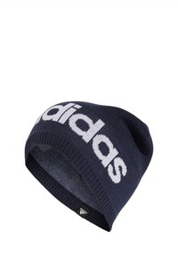 Navy knit beanie with a white "adidas" logo. Features a ribbed cuff and smooth texture. Includes a small black brand tag at the hem.
