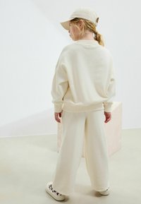 Next REGULAR FIT -  JOGGERS SET - Träningsset - ecru slogan