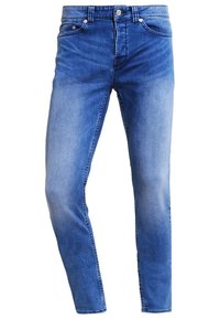 Jeans de mezclilla azul claro con un corte slim, diseño de cinco bolsillos, cierre de un solo botón y un ligero desgaste en los muslos.