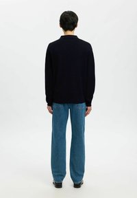 Camicia a maniche lunghe blu navy con colletto, abbinata a jeans a gamba larga blu chiaro. Texture liscia e vestibilità comoda, vista da dietro.