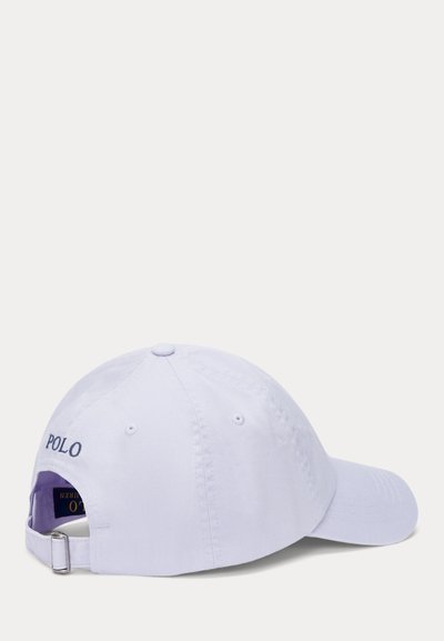 Vit bomull-baseballkeps med justerbar rem, med "POLO" broderat i marinblått på baksidan. Rundad krön och design med böjd skärm.