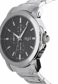 Silver stainless steel watch with a black dial, three sub-dials, silver hour markers, and a crown on the side. Text reads "regal" and "JAPAN MOVT."