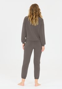 Ensemble de vêtements de détente gris comprenant un haut à manches longues à coupe décontractée avec des poignets et un pantalon fuselé avec des poignets élastiques, fabriqué à partir de matériaux doux.