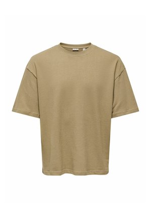 Beige oversized kortærmet bomulds-T-shirt med rund halsudskæring og synlige syninger på ærmer og kant, vist på en hvid baggrund.