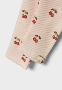 Roze ribstof met een kersendessin in rood en groen. Afgewerkt met een klein label aan de zoom.